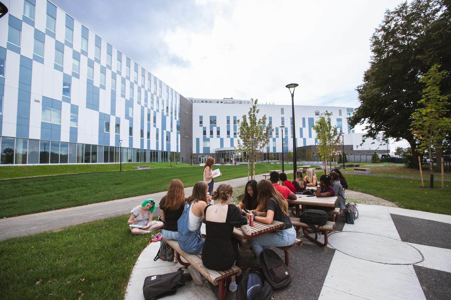 uOttawa students at a picnic table outside the Faculty of Health Sciences Building