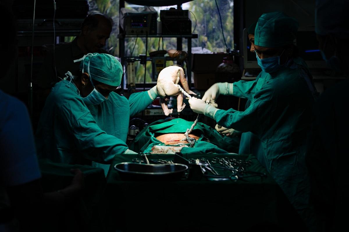 Operating room scene of baby being delivered by caesarian