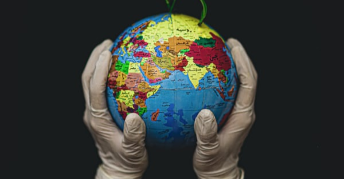 Hands (with gloves on) holding a globe