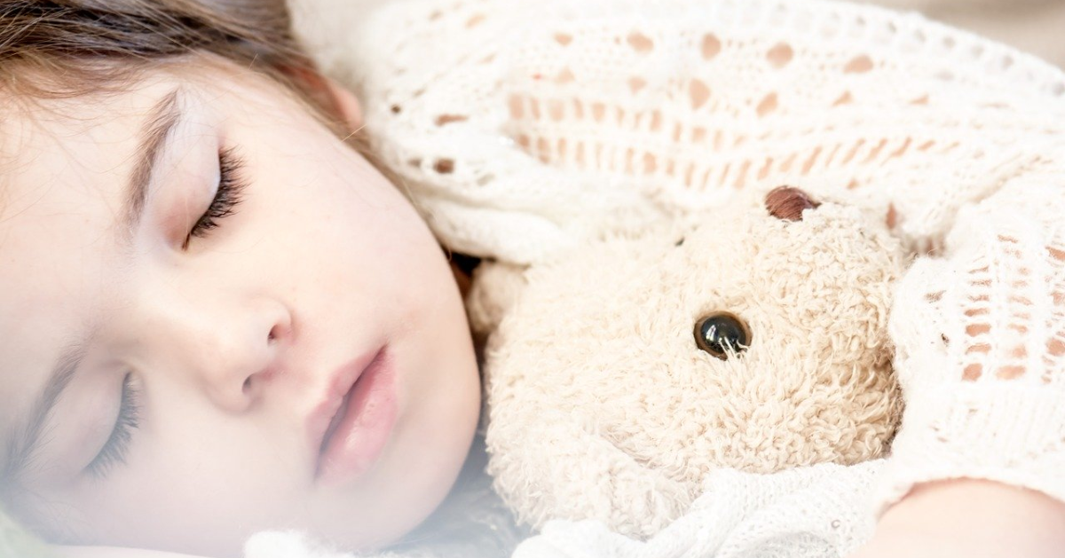 Little girl sleeping with her teddy bear