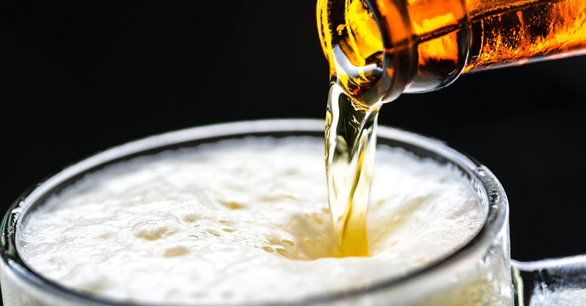 Beer bottle being emptied in a glass