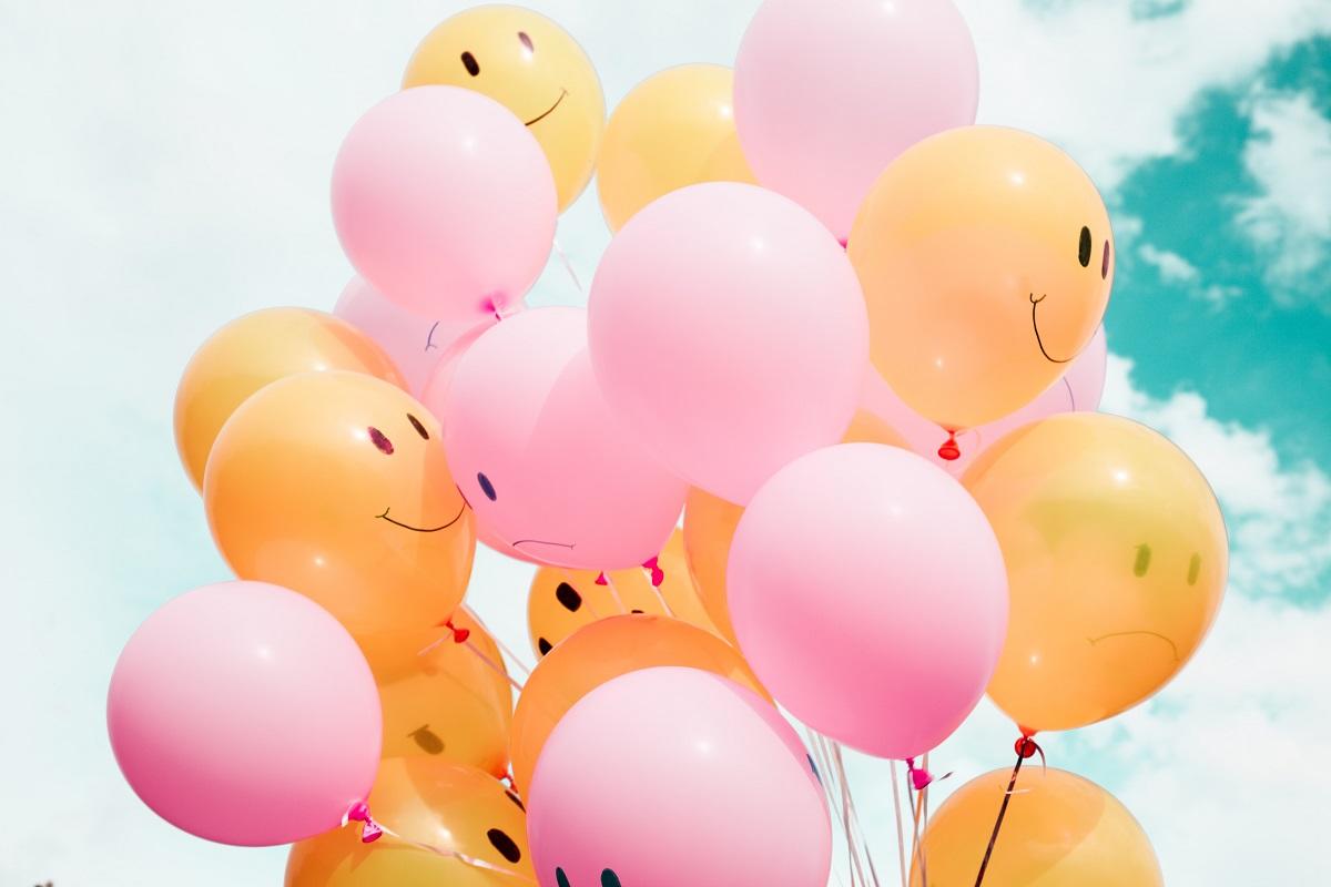 Mix of colorful balloons featuring happy and sad faces