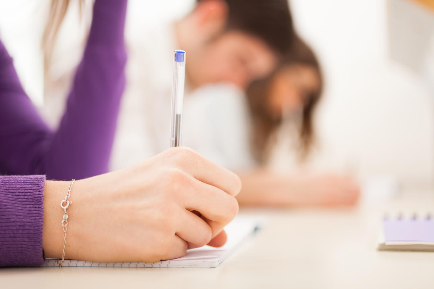 plan rapproché d'une main qui écrit au stylo