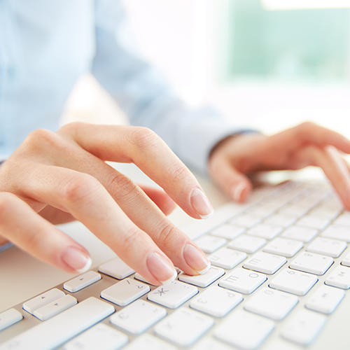 plan rapproché de mains qui tapent sur un clavier d'ordinateur