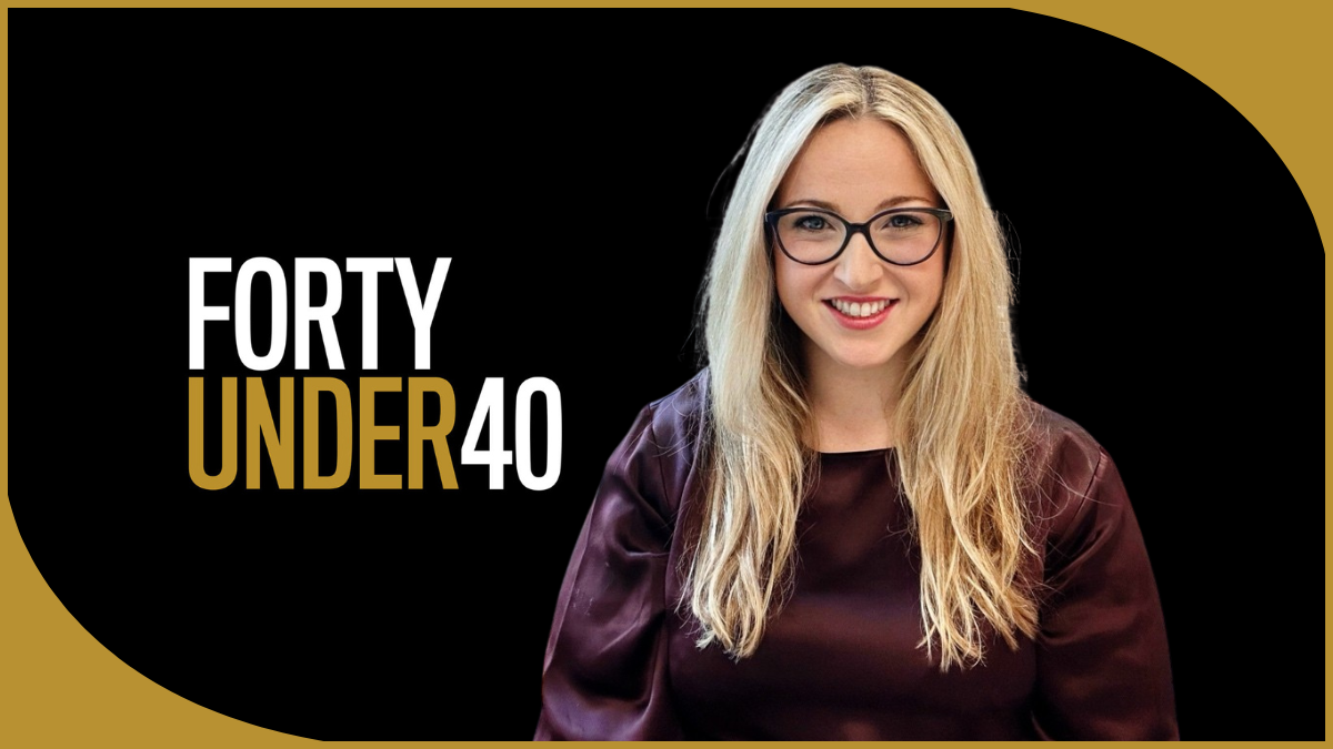 A woman with glasses, smiles at the camera. The logo for Forty Under 40 is placed on the left.