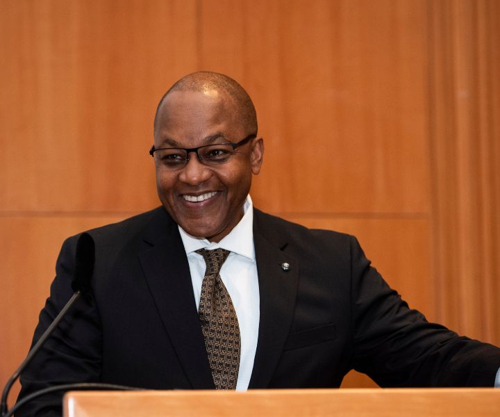 Chief Justice of Ontario, Michael Tulloch, stands smiling at a podium