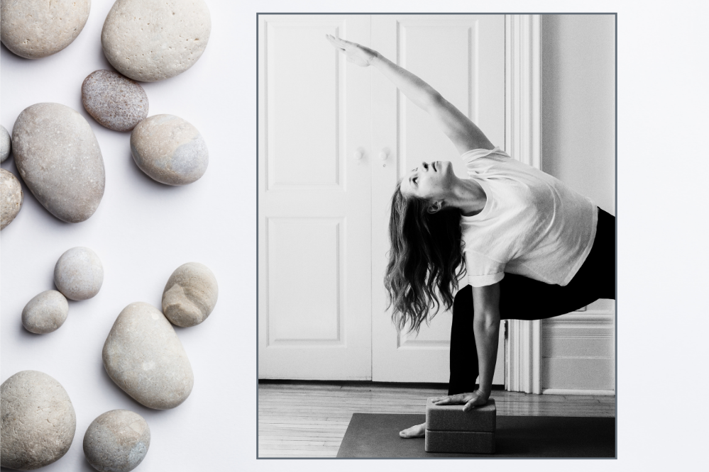 A woman does a yoga pose on a yoga mat