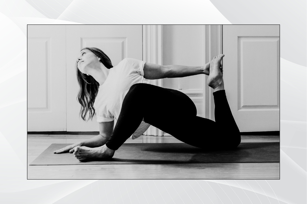 a woman does a yoga pose on a mat