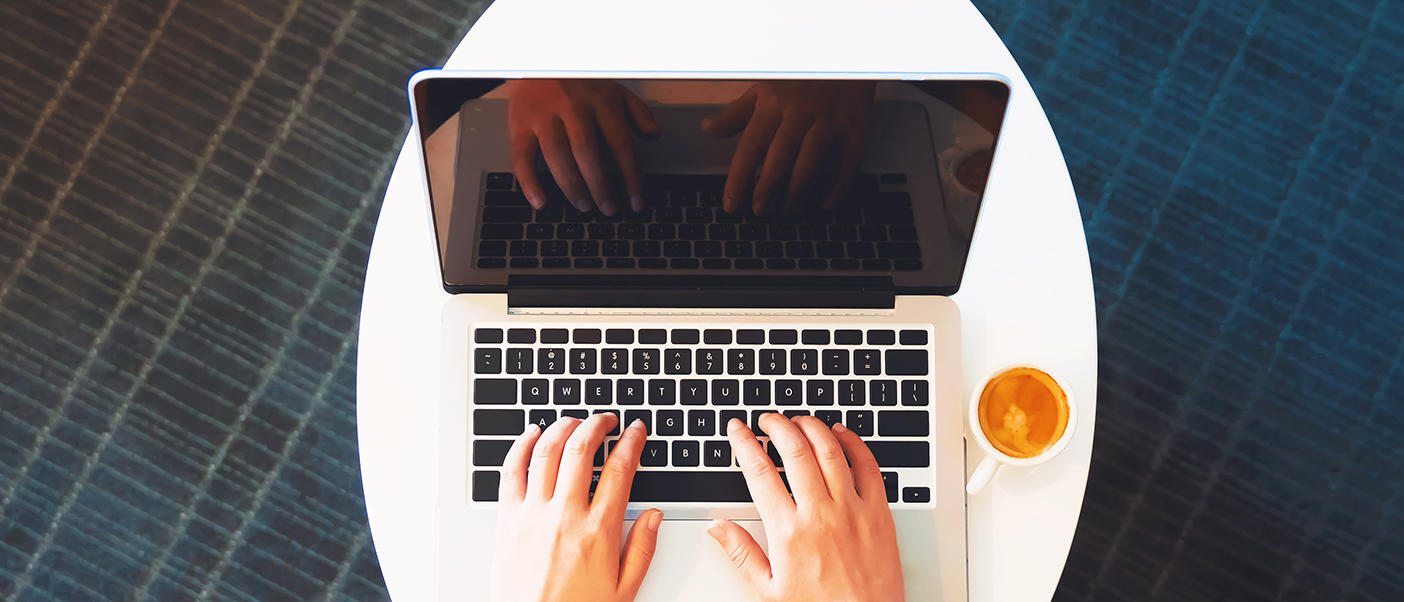 Hands typing on a laptop
