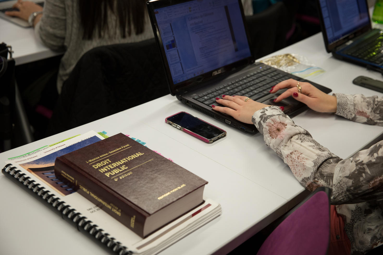 Une étudiante prend des notes pendant un cours de droit