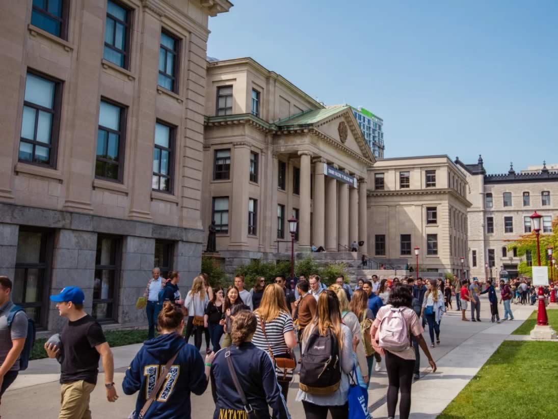 Des étudiants marchant devant le pavillon Tabaret en été.