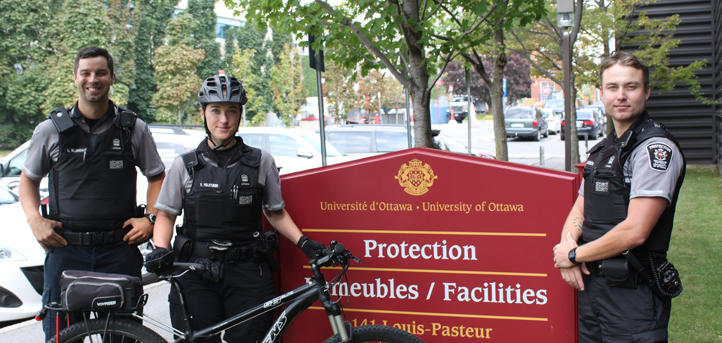 Des employés des services de protection se tiennent devant le signe de protection.