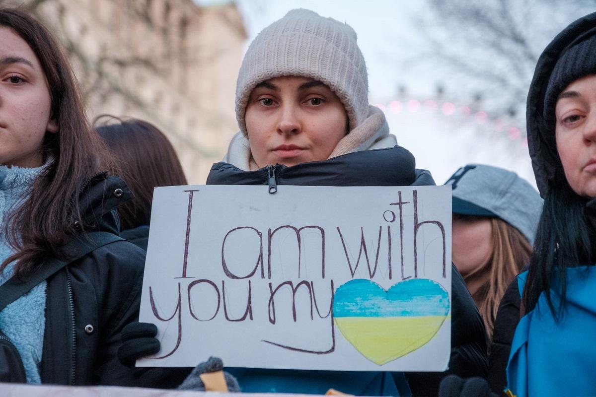 Une femme parmi un groupe de femmes tenant une pancarte sur laquelle on peut lire "Je suis avec toi, mon Ukraine".