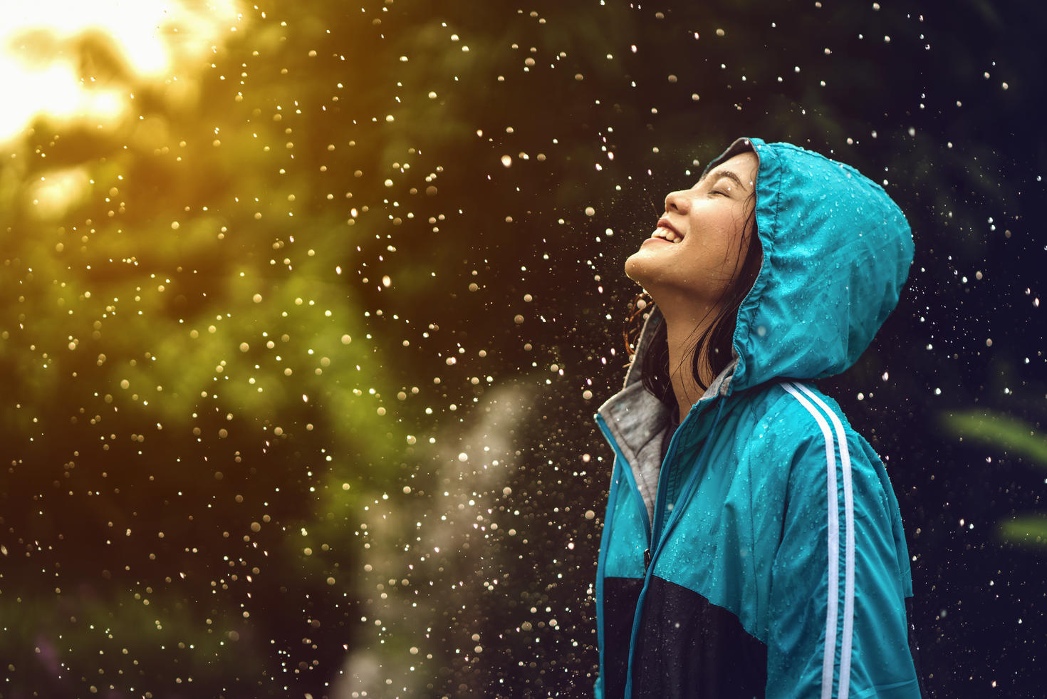 Jeune femme qui éclate de rire sous la pluie