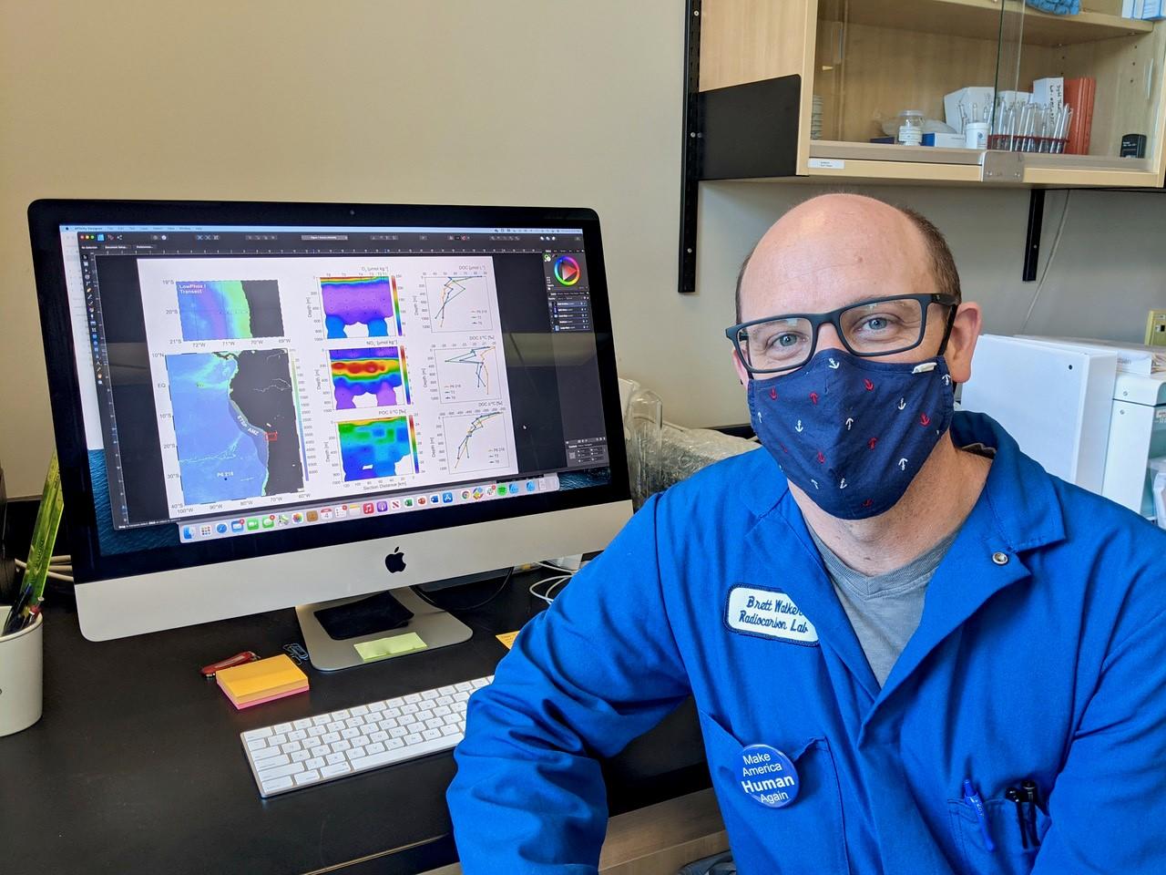 Brett Walker in front of his computer screen showing data