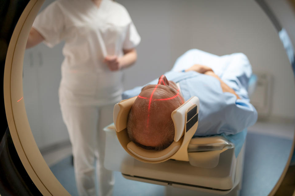 Un laser recouvre le crâne d'un homme chauve lors de son passage au scanner.