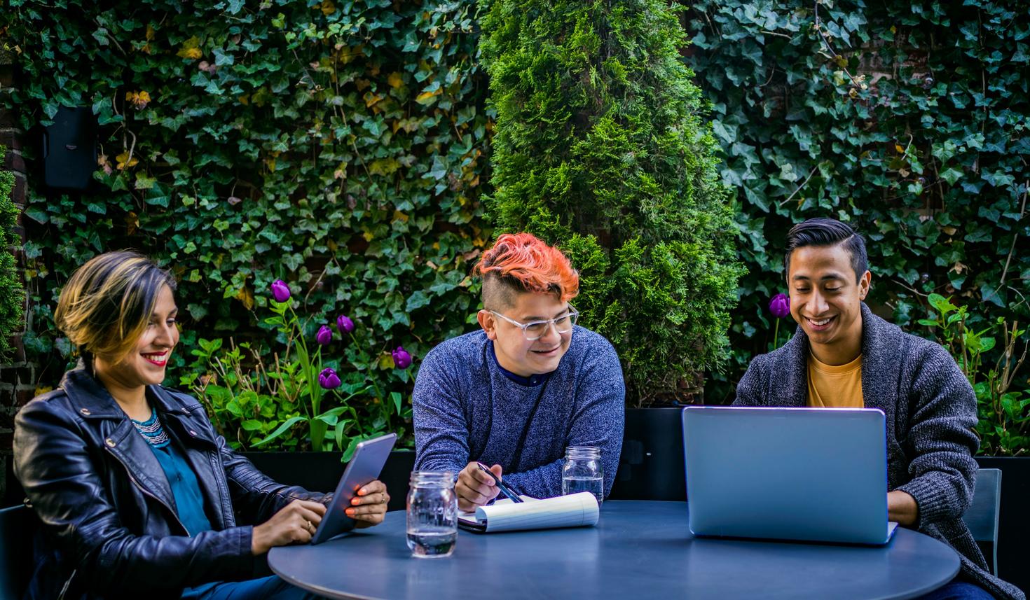 Trois personnes à une table avec leurs ordinateurs.