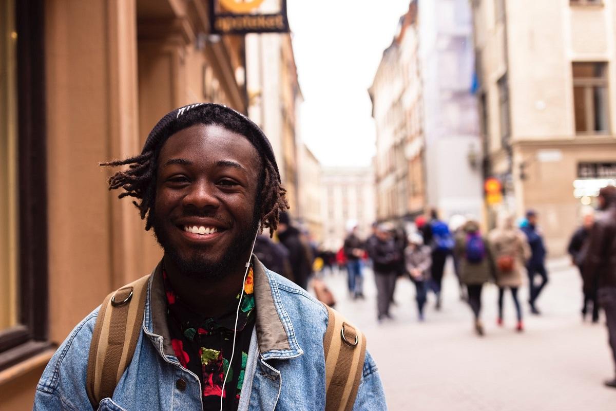 Jeune noir souriant dans une rue de la ville