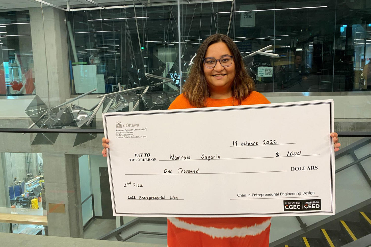 Namrata Bagaria tient dans ses mains un chèque géant d'une valeur de 1000 $.