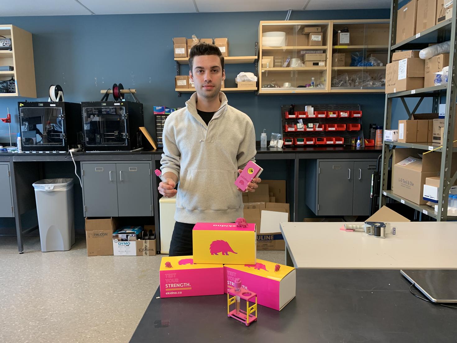 Nic Boileau pose avec des produits Ekidna dans un laboratoire