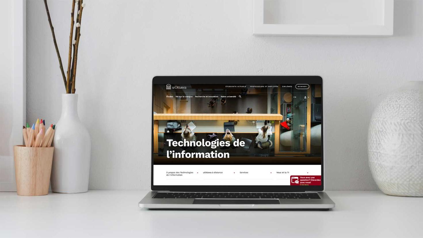 Un ordinateur portable sur un bureau de travail affiche la page d'accueil du nouveau site Web TI.