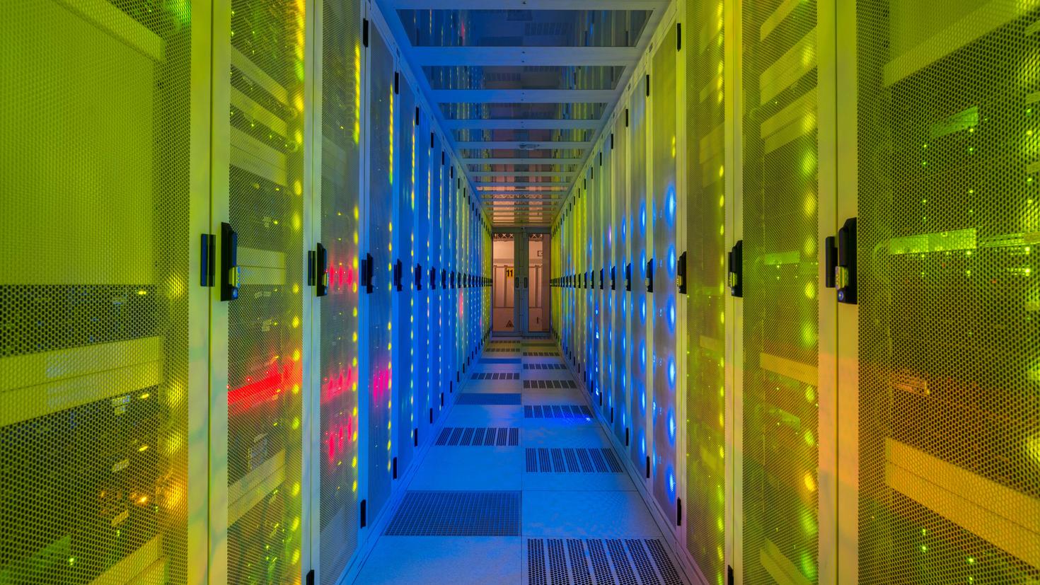 Une salle de serveurs de centre de données avec des lumières colorées.