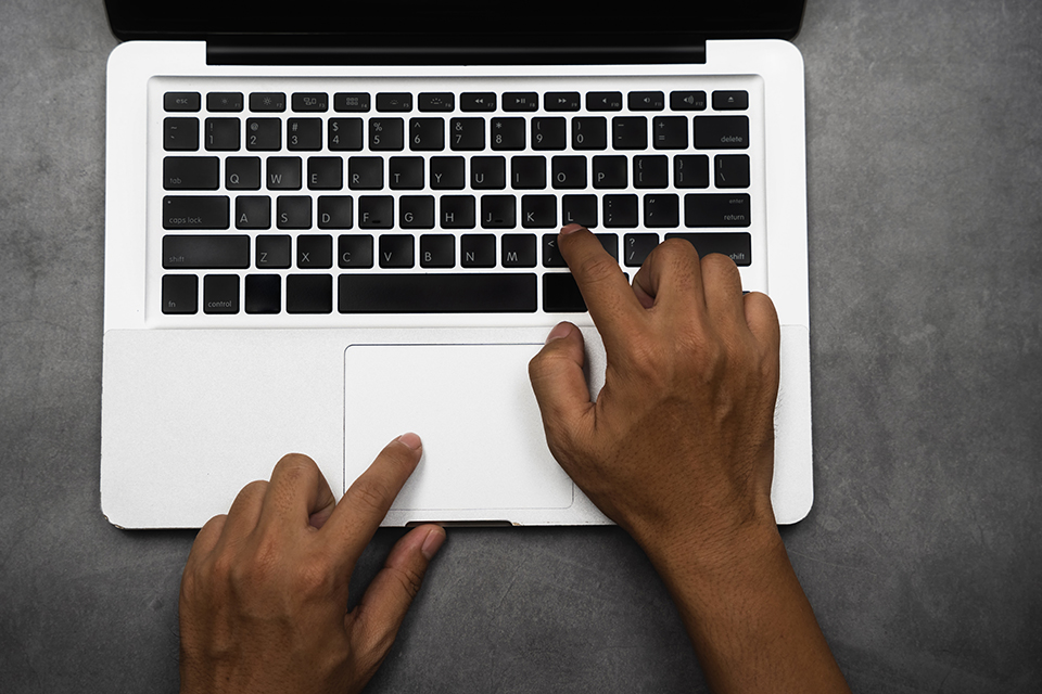 Vue de haut deux mains sur un clavier d'ordinateur portable