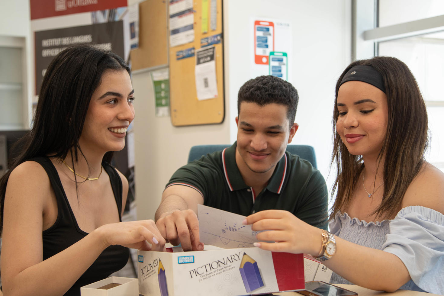 Three students playing Pictionary at the Julien Couture Resource Centre