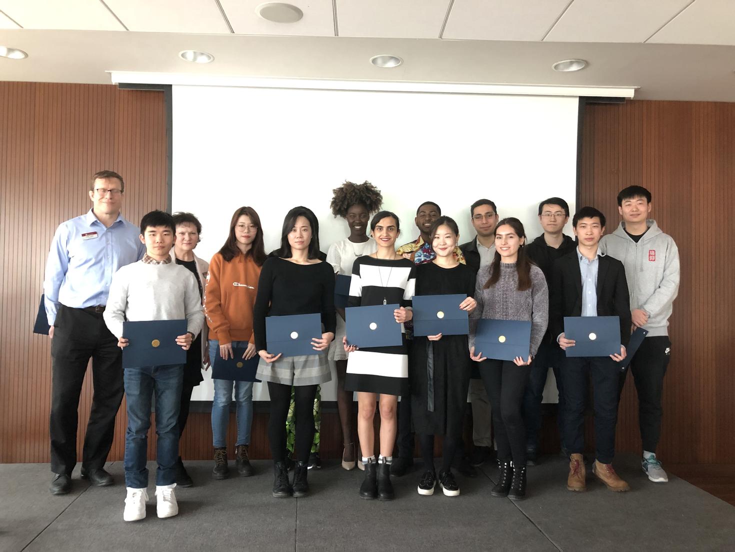 étudiants tenant des certificats sur scène