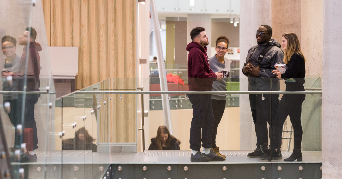Un groupe d'étudiants debouts, discutent entre eux.