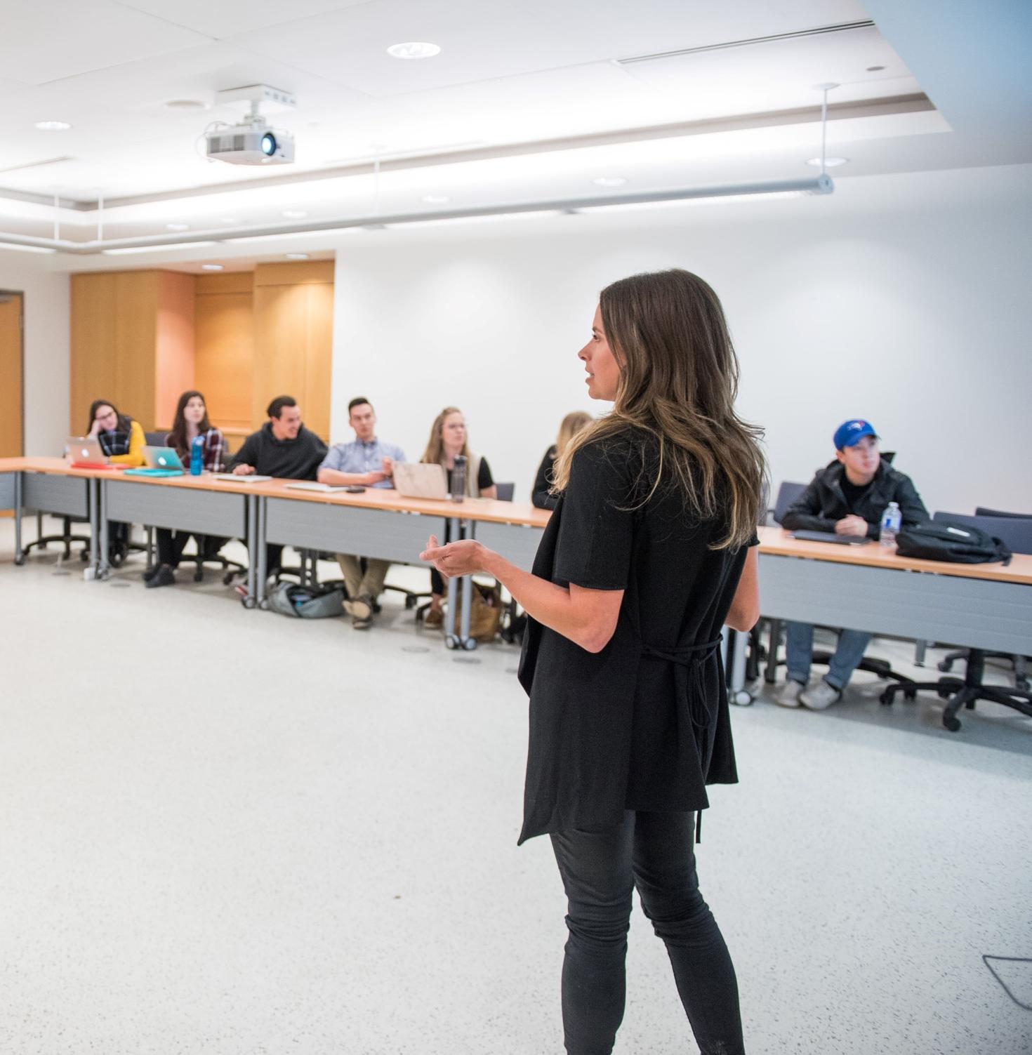 personne faisant une présentation devant des étudiants dans une salle de classe