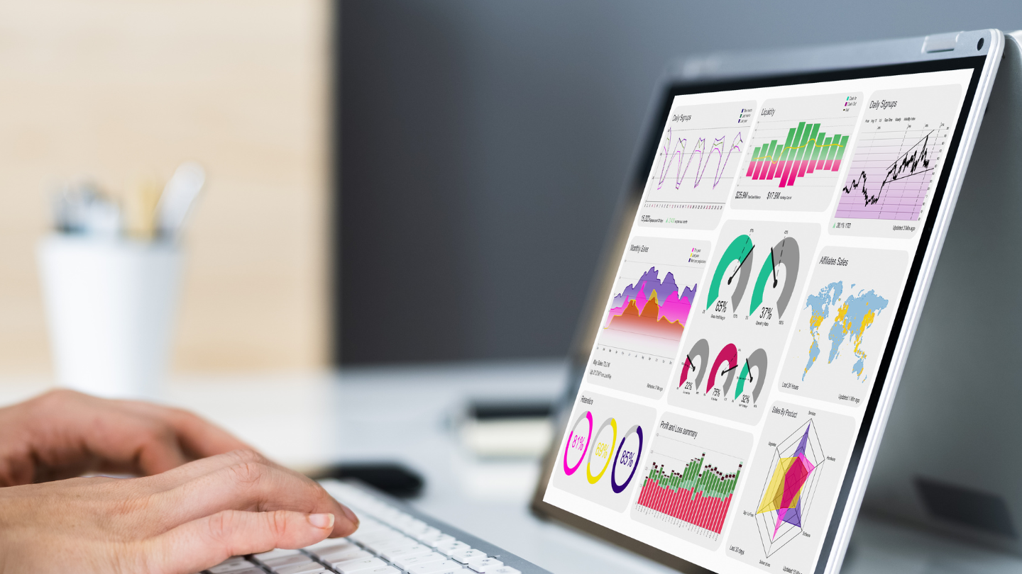 Mains qui tapent sur un clavier d'ordinateur portable dont l'écran affiche des graphiques symbolisant des bases de données