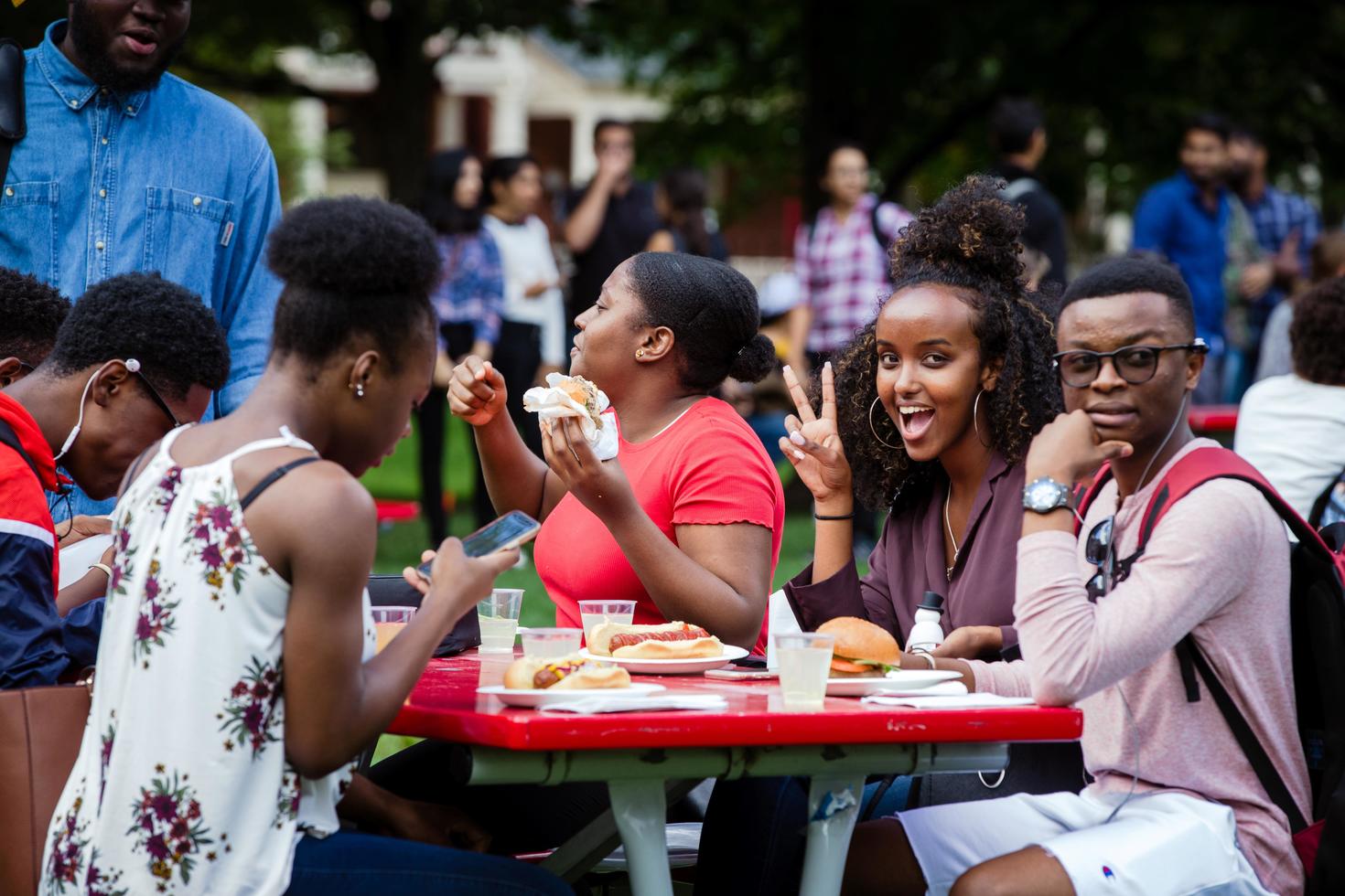 groupe d'étudiants mangeant à une table de pique-nique sur le campus