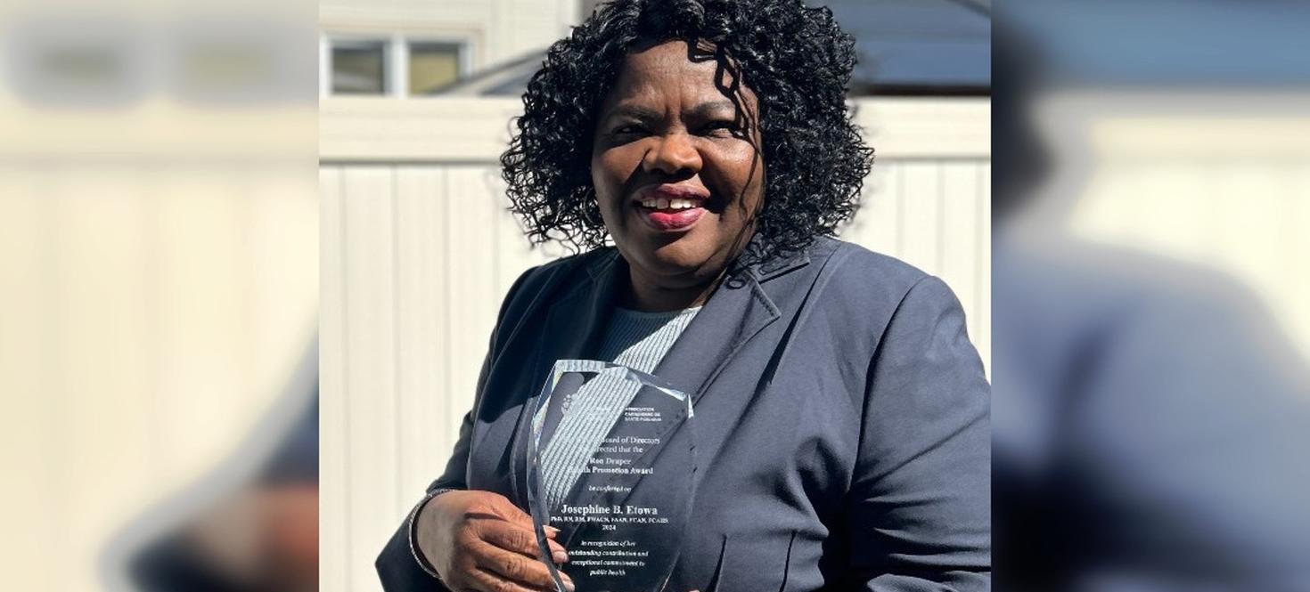Josephine Etowa holding her award