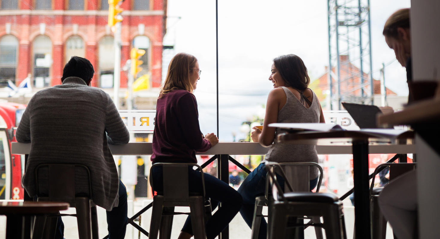 Personnes travaillant et discutant à l'intérieur d'un café