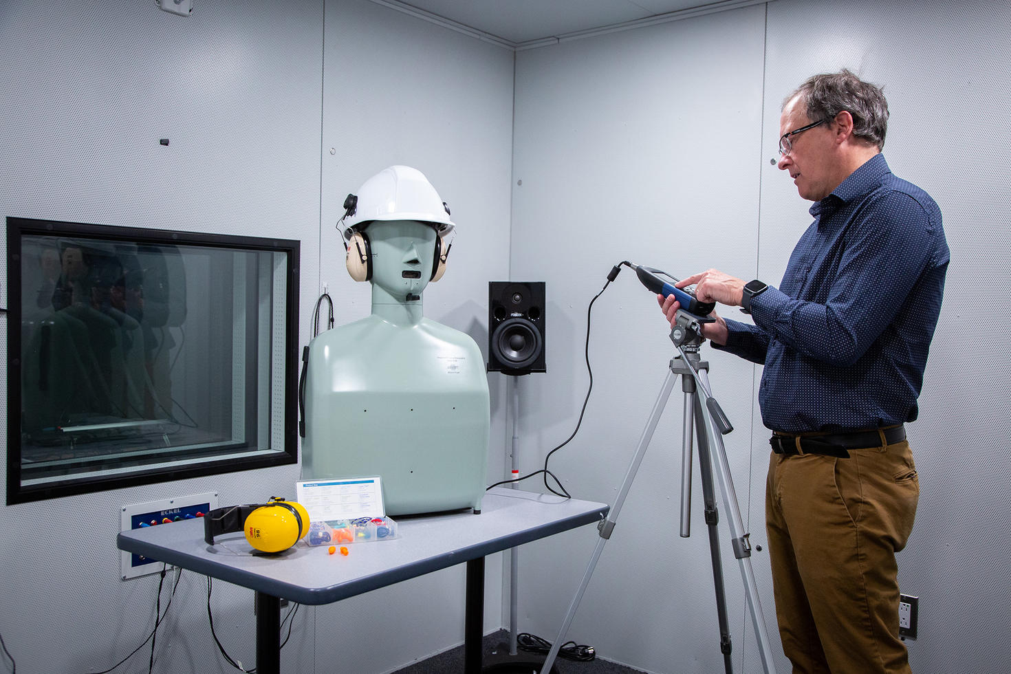 Christian Giguère effectue des tests sur une tête de mannequin portant un casque d'écoute