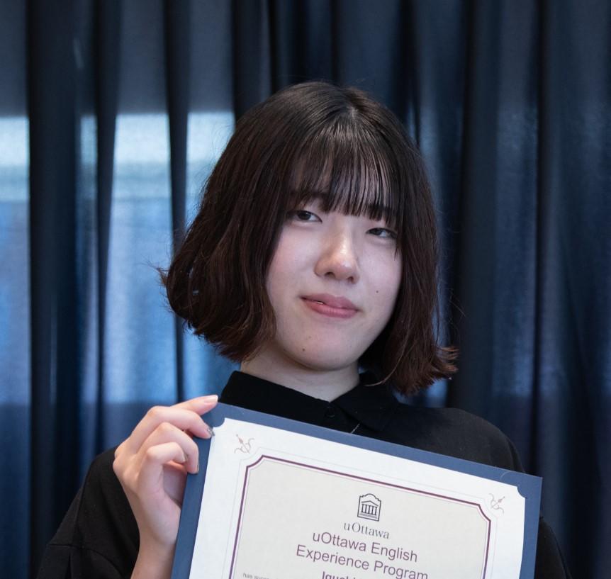 Une étudiante tient son certificat