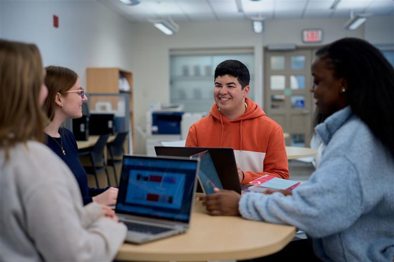 Four students sitting at a table together at the Julien Couture Resource Centre