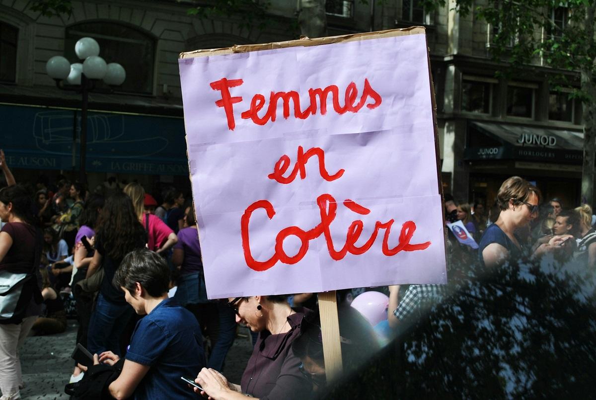 Femme potestor avec une pancarte indiquant « Femmes en colere ».