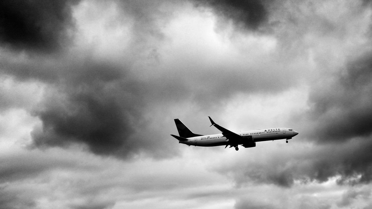 Image en noir et blanc de l'avion Delta dans le ciel