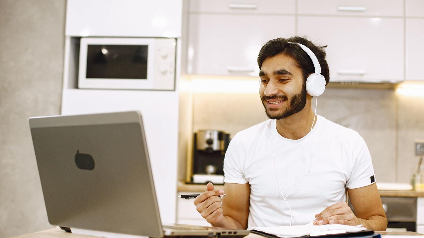 Un homme entrain d'utiliser son ordinateur portable.