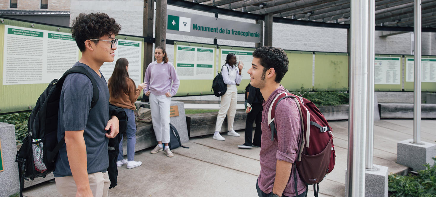 Des étudiants discutent devant le monument de la francophonie