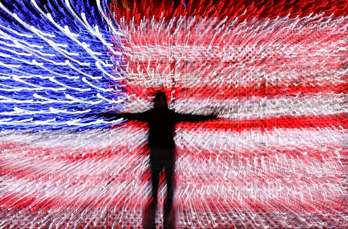 Silhouette se découpant sur un drapeau américain flou