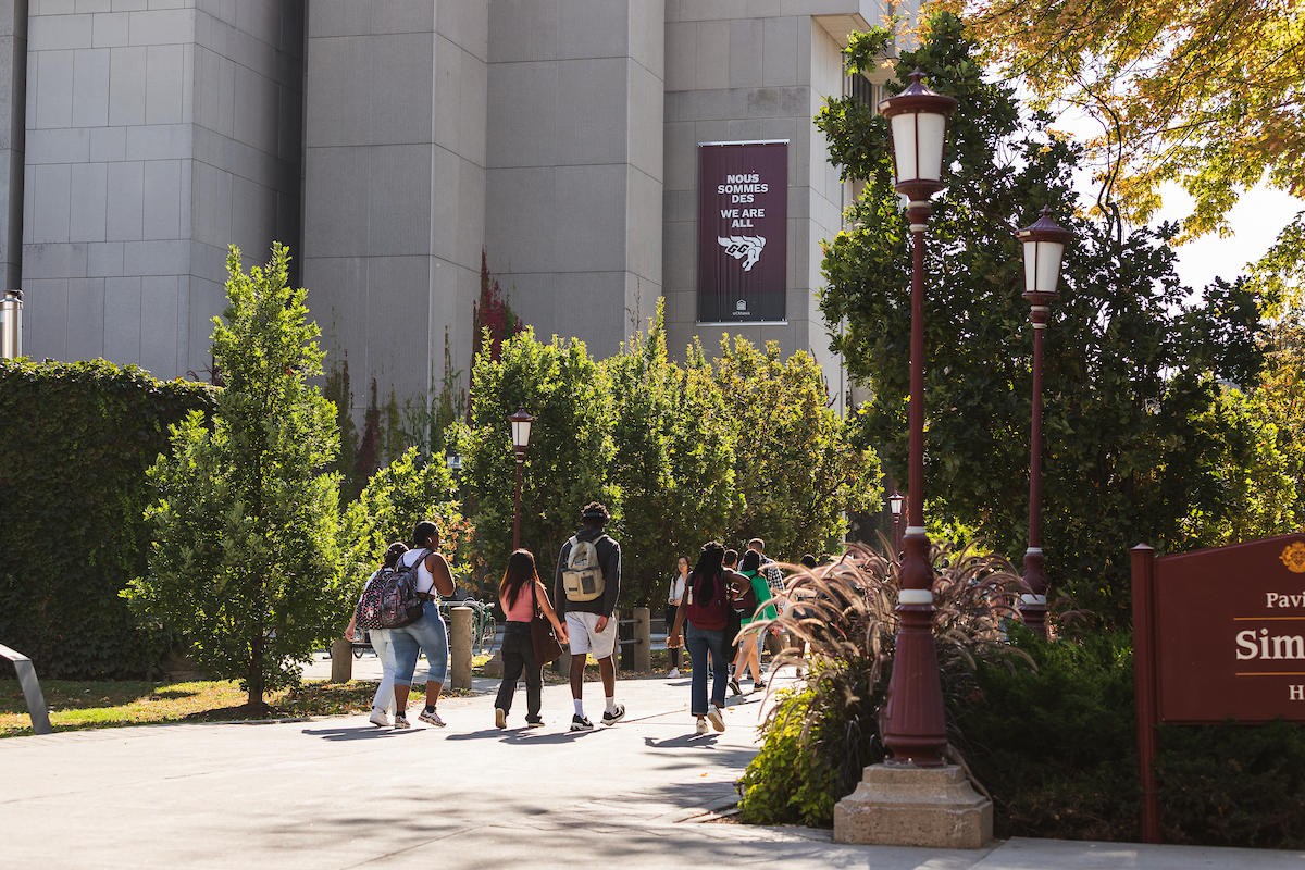 Étudiantes et étudiants traversant le campus à pied. 