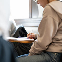 Un étudiant assis à un bureau en train d'écrire