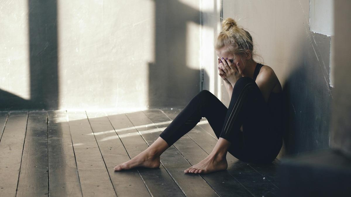 Femme assise par terre en train de pleurer
