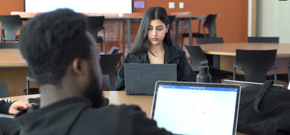 Capture d'écran d'un moment de la vidéo montrant des étudiants en train d'étudier avec leurs ordinateurs portables.