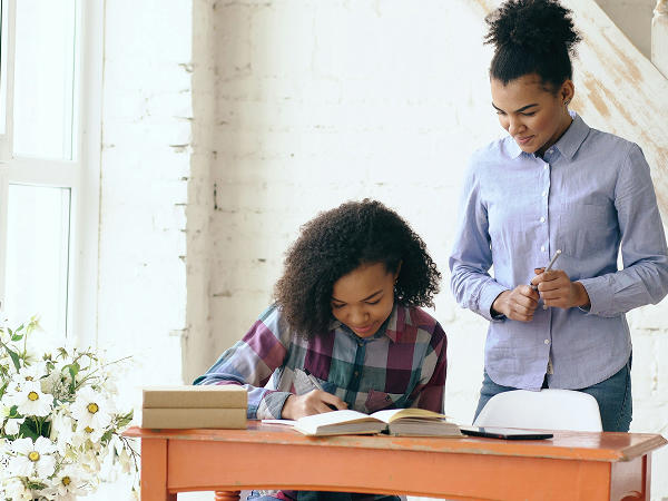 Une mère et sa fille qui font leurs devoirs ensemble