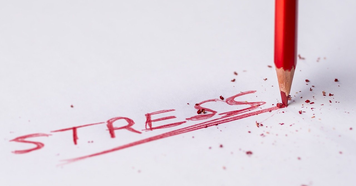 Le mot ''stress'' écrit en rouge sur une feuille de papier
