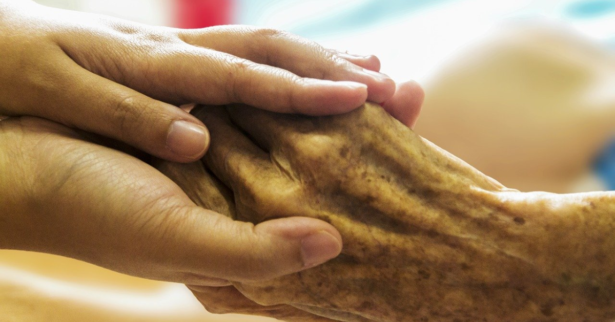 Une personne qui tient la main d'une personne âgée